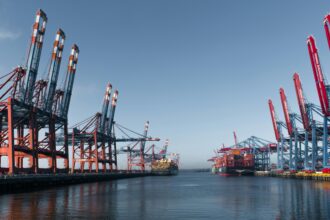 Panoramic view of Hamburg's bustling container terminal highlighting cranes and cargo ships.